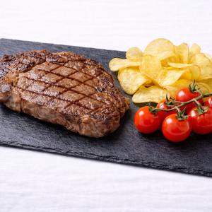 Bandeja de pizarra natural de 40 × 20 cm con carne a la plancha y patatas doradas, presentación estilo taberna