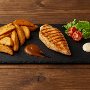 Plato de pizarra natural de 40 × 16 cm con pollo a la plancha, patatas doradas, ensalada fresca y salsas, estilo taberna