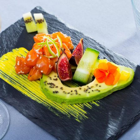 Plato de pizarra natural de 30x20 cm con aguacate, salmón e higos, ideal para presentaciones gourmet y creativas