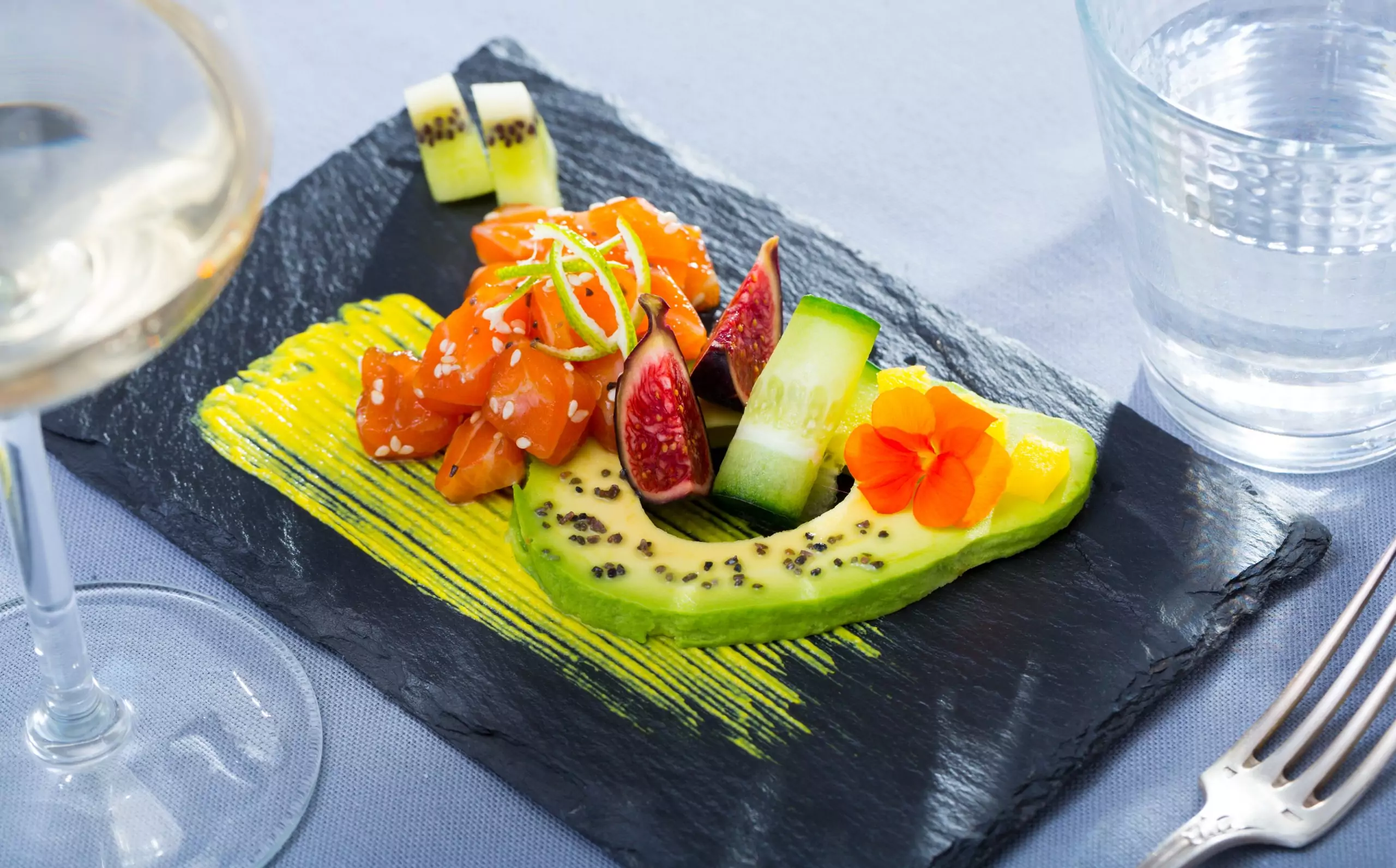 Plato de pizarra natural de 30x20 cm con aguacate, salmón e higos, ideal para presentaciones gourmet y creativas