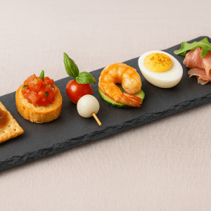 Plato de pizarra natural de 30 × 10 cm con seis aperitivos gourmet variados y coloridos