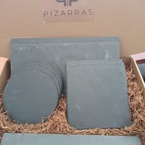 Pack de platos y bandejas de pizarra natural en diferentes formatos presentados en caja, ideales para servir aperitivos, carnes y postres