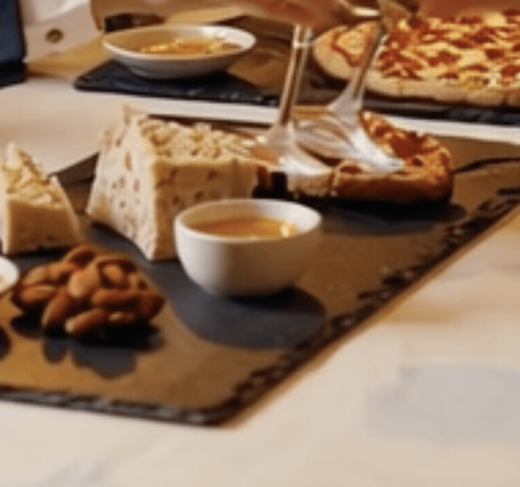 Reunion de amigos con entrantes, pizza sobre platos de pizarra natural